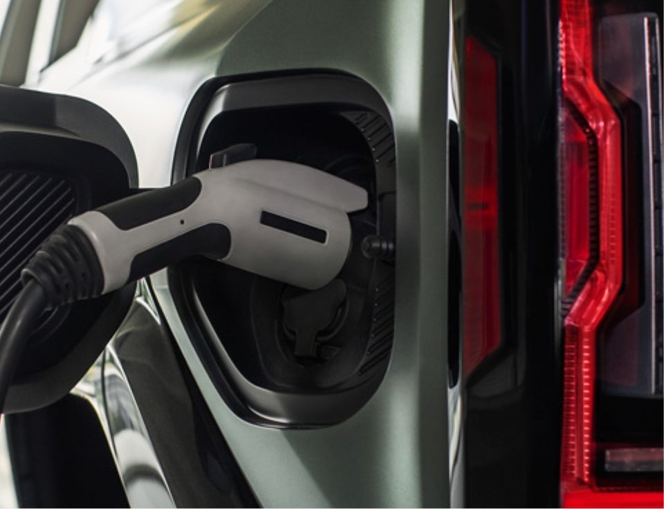 Close up of charging port with charger plugged in on a GMC Hummer EV SUV - Auto Town GMC in Gladstone OR
